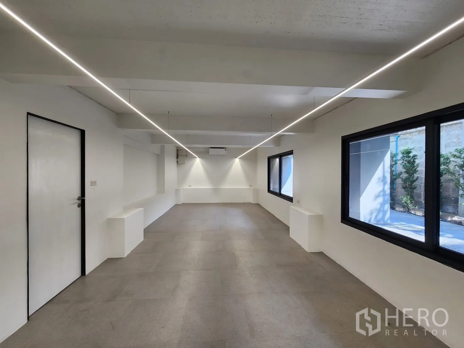 家庭办公室 for rent in Chatuchak, Bangkok - 一层工作空间，瓷砖地面、白墙与长条线性灯。