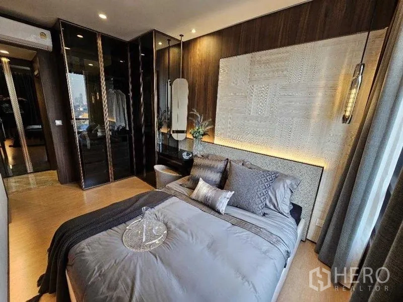 คอนโด ให้เช่า - ห้องนอนหลักหัวเตียงลายเท็กซ์เจอร์ โคมแขวน และตู้เสื้อผ้าบานกระจก