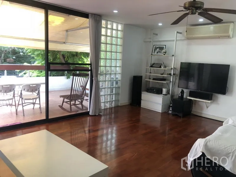 ทาวน์เฮาส์ ให้เช่าหรือขายในBangkok - พื้นที่นั่งเล่น ประตูบานเลื่อนออกระเบียงกว้าง ผนังทีวี บล็อกแก้ว และพื้นไม้
