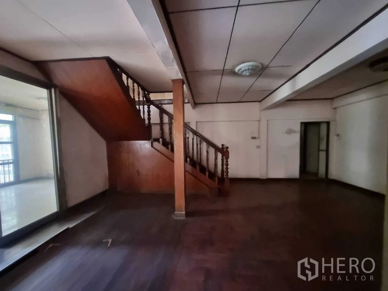 Detached House for rent or sale in Watthana, Bangkok - Interior showing wooden staircase and open rooms ready for renovation.