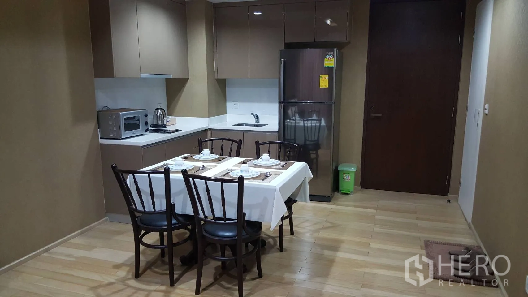 คอนโด ให้เช่าในKhlong Toei, Bangkok - ครัวรูปตัวแอลพร้อมตู้เย็น ไมโครเวฟ และโต๊ะทานข้าว 4 ที่นั่ง