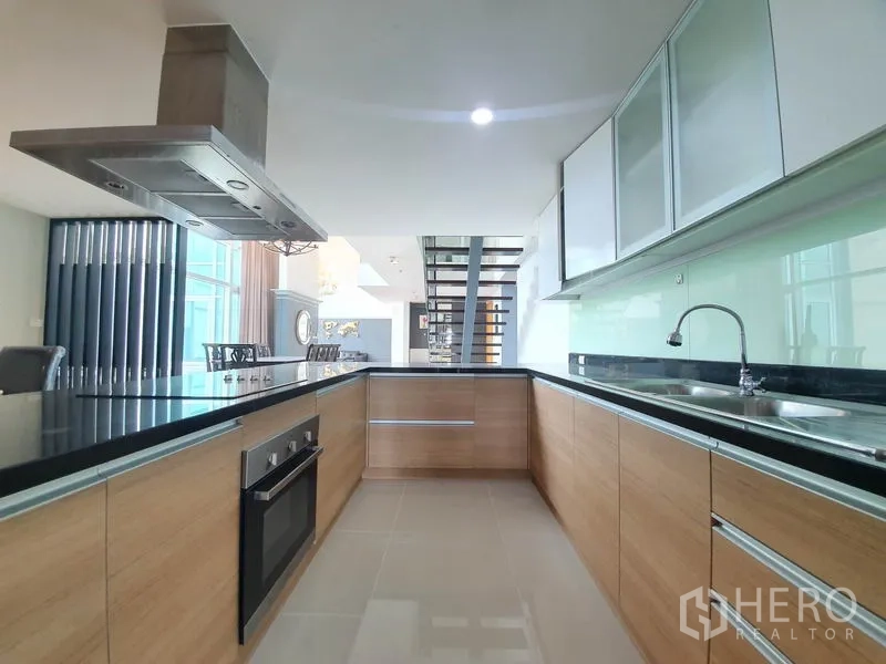 คอนโด ให้เช่าในRatchathewi, Bangkok - ห้องครัวรูปตัว U พร้อมเตาอบ เครื่องดูดควัน เคาน์เตอร์สีดำ และตู้ไม้ดีไซน์โมเดิร์น.