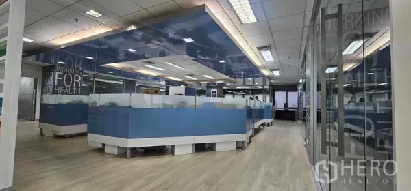 สำนักงาน ให้เช่าในBang Rak, Bangkok - พื้นที่ทำงานเปิดโล่งพร้อมโต๊ะทำงานแบบคลัสเตอร์สีน้ำเงิน ไฟฝ้าทีบาร์และผนังกระจก