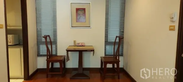 คอนโด ให้เช่าในSathon, Bangkok - มุมรับประทานอาหารขนาดกะทัดรัด เก้าอี้ไม้สองตัวกับโต๊ะเล็ก ระหว่างหน้าต่างแคบ ติดกับทางเข้าห้องครัว