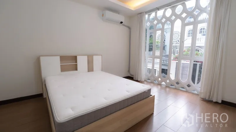 ทาวน์เฮาส์ ให้เช่าในWatthana, Bangkok - ห้องนอนมีหน้าต่างบานใหญ่และฉลุลาย เปิดออกสู่ระเบียง