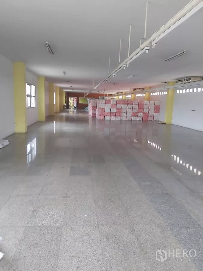 Warehouse for rent in Krathum Baen, Samut Sakhon - Open‑plan warehouse floor with polished tiles, windows, fluorescent lighting and stacked boxes.