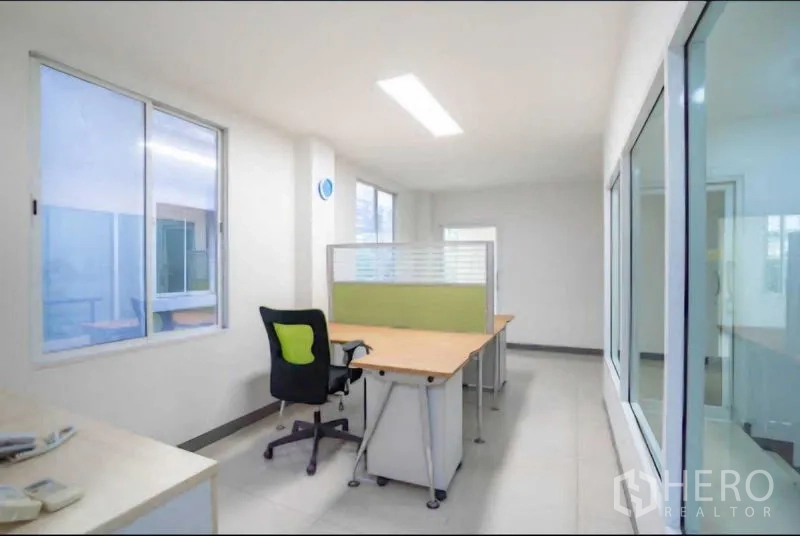 Home Office for rent or sale in Lat Krabang, Bangkok - Workstation zone with green task chair and partitioned desk in a clean white office.
