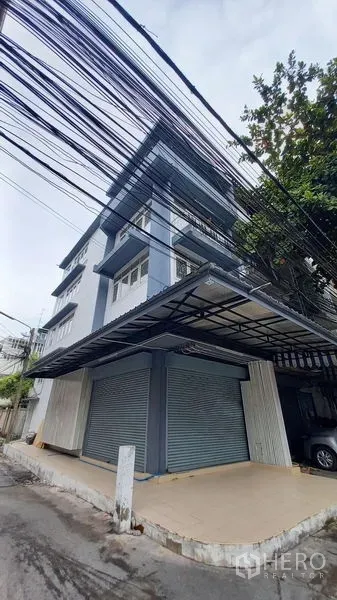 อาคารพาณิชย์ ให้เช่าในBangkok - มุมมองริมถนนของอาคารพาณิชย์ พร้อมกันสาดกว้างและประตูลูกกลิ้งคู่.