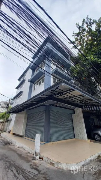 อาคารพาณิชย์ ให้เช่าในBangkok - มุมมองริมถนนของอาคารพาณิชย์ พร้อมกันสาดกว้างและประตูลูกกลิ้งคู่.