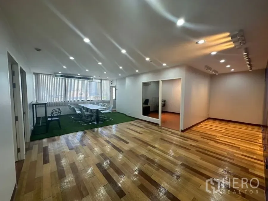 สำนักงาน ให้เช่าในYan Nawa, Bangkok - พื้นที่ทำงานโอเพ่นสเปซ ปูพื้นไม้ มีโต๊ะประชุมยาวบนพรมสีเขียว และห้องกั้นสองห้อง