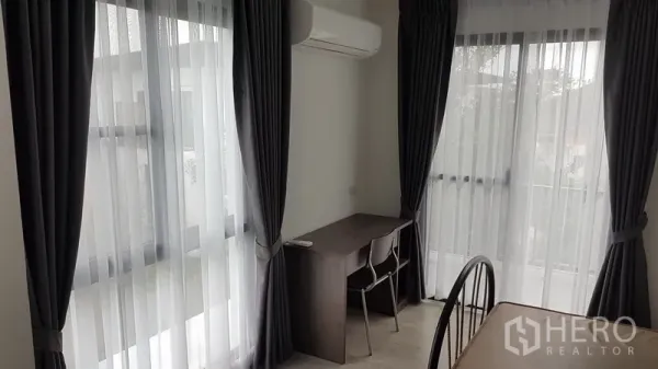 独立式住宅 出租在Prawet, Bangkok - 转角学习区，书桌与椅子、空调及大面积窗景。