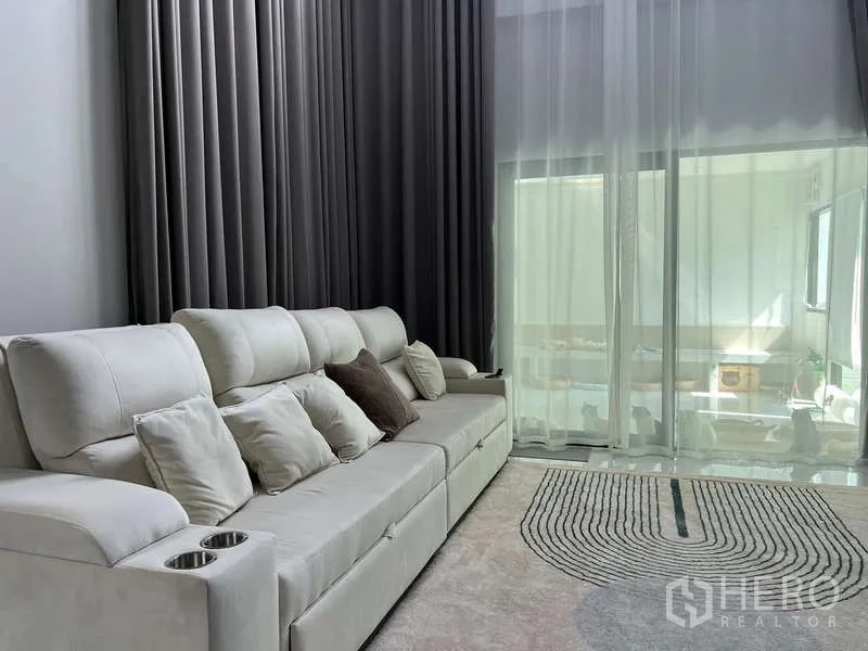 Detached House for rent in Bang Phli, Samut Prakan - Long sofa beside tall curtains and sliding glass to the terrace.