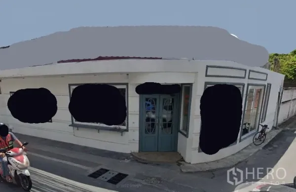 零售空间 出租在Watthana, Bangkok - 转角临街店面外观，白色立面、青色双开门与大幅展示窗。