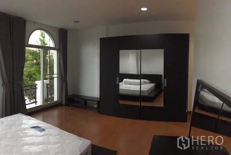 ทาวน์เฮาส์ ให้เช่าในLat Phrao, Bangkok - ห้องนอนใหญ่พร้อมตู้เสื้อผ้าบานใหญ่ กระจกเงา และพื้นไม้