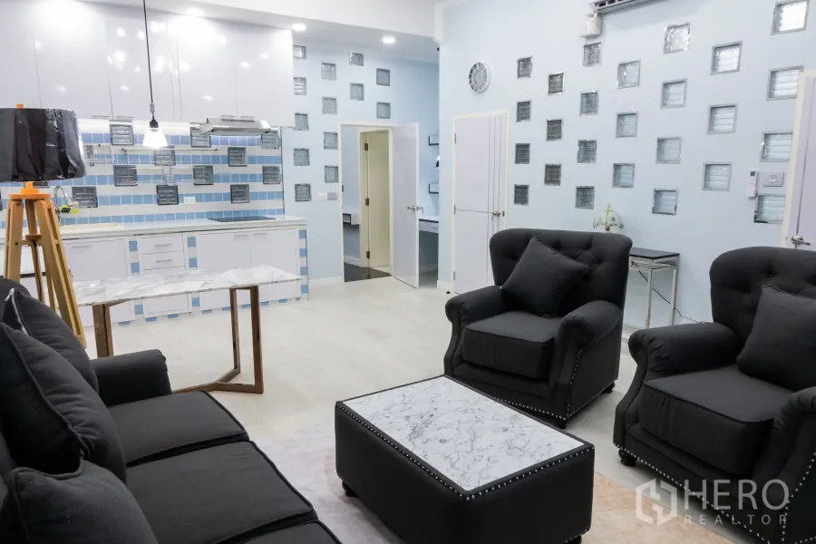 คอนโด for rent or sale in Khlong Toei, Bangkok - พื้นที่นั่งเล่นโอเพ่นแพลนกว้าง โคมแขวน และผนังกระจกบล็อก