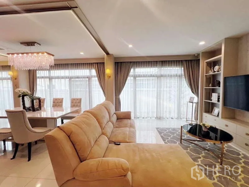 Detached House for rent or sale in Bang Phli, Samut Prakan - Open-plan lounge and dining space with large sofa and TV wall.