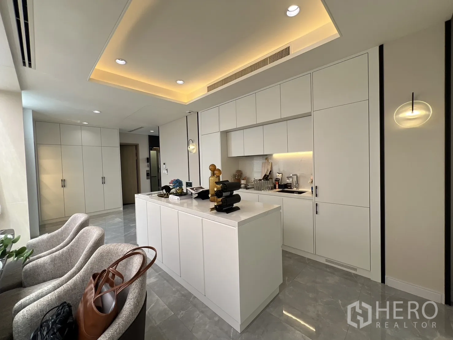 Semi-detached House for sale in Yan Nawa, Bangkok - White kitchen with island counter, overhead cabinets, and marble-look floors.