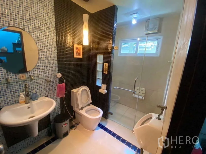Detached House for sale in Suan Luang, Bangkok - Guest bathroom with mosaic walls, glass shower and sanitary ware.