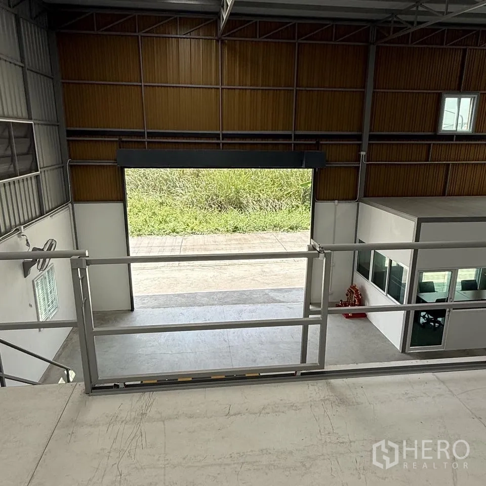 仓库 for rent or sale in Khlong Luang, Pathum Thani - 从夹层俯视大型卷闸门与一层办公室。