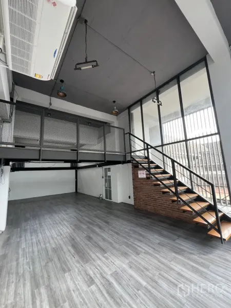 Home Office for rent in Mueang Nonthaburi, Nonthaburi - Double-height workspace with mezzanine, steel staircase and grey vinyl flooring.