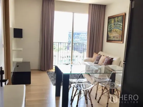 คอนโด ให้เช่าในKhlong Toei, Bangkok - พื้นที่นั่งเล่นและรับประทานอาหารสว่าง โต๊ะกระจก พื้นไม้ และระเบียงวิวเมือง.