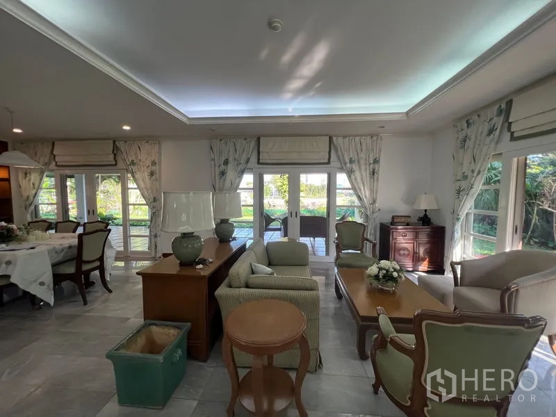 Detached House for rent in Bang Phli, Samut Prakan - Open-plan living and dining area with glass doors connecting to a covered patio and landscaped garden.