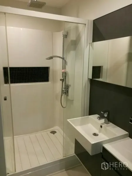 Condominium for rent in Phra Khanong, Bangkok - Contemporary bathroom featuring a glass-enclosed rain shower and a square basin vanity.