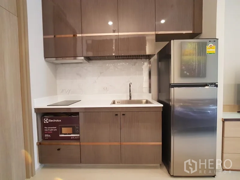 คอนโด ให้เช่าในPathum Wan, Bangkok - ครัวบิลท์อินตู้เงา เตาไฟฟ้า อ่างล้างจาน ตู้เย็น และไมโครเวฟ