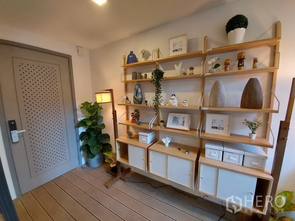Condominium for rent in Watthana, Bangkok - Entry foyer with display shelving, floor lamp and indoor plant.