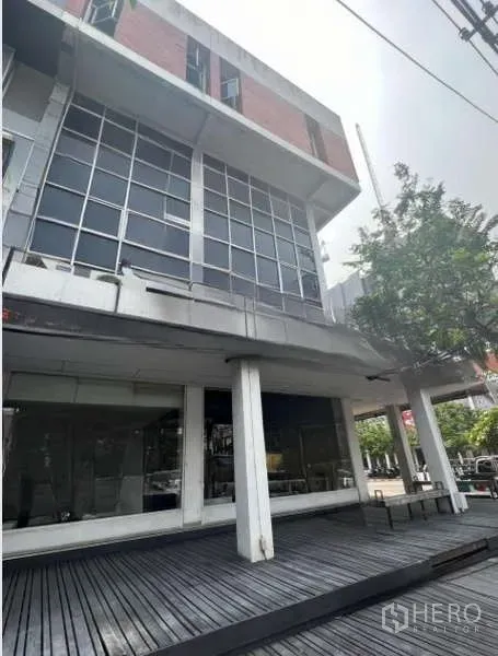 店屋 出租或出售在Khlong Toei, Bangkok - 多层商铺外立面角度图，带木平台与大窗