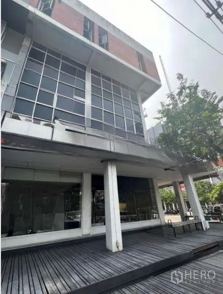 店屋 出租或出售在Khlong Toei, Bangkok - 多层商铺外立面角度图，带木平台与大窗