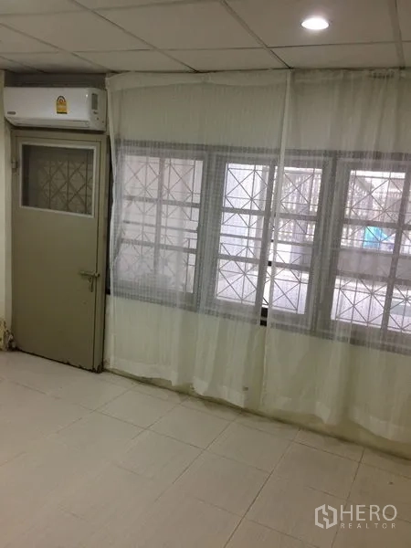 ทาวน์เฮาส์ ให้เช่าในKhlong Toei, Bangkok - ห้องอเนกประสงค์สว่าง มีผ้าม่านโปร่งและแอร์แขวนผนัง