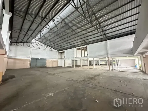 Factory for rent or sale in Khlong Luang, Pathum Thani - Spacious production hall with high steel truss roof and loading doors.