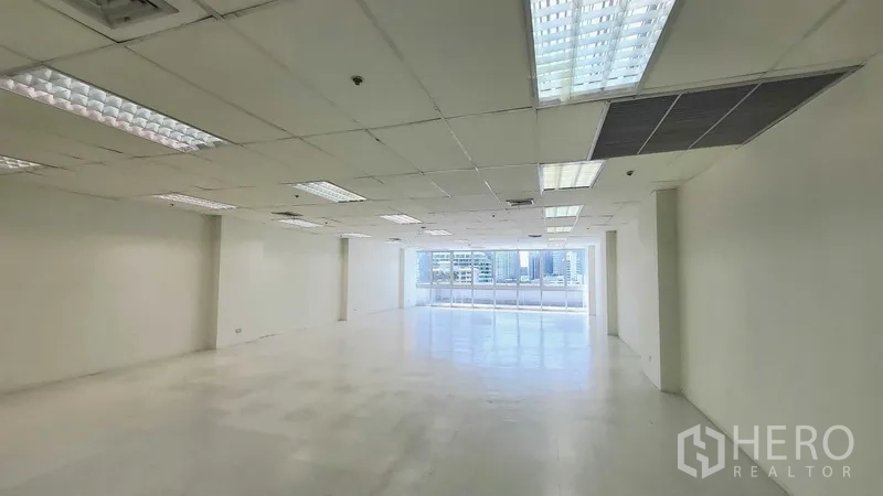 สำนักงาน ให้เช่าในKhlong Toei, Bangkok - พื้นชั้นสำนักงานกว้าง ผนังสีขาว ฝ้าทีบาร์พร้อมไฟ และแสงธรรมชาติจากหน้าต่าง