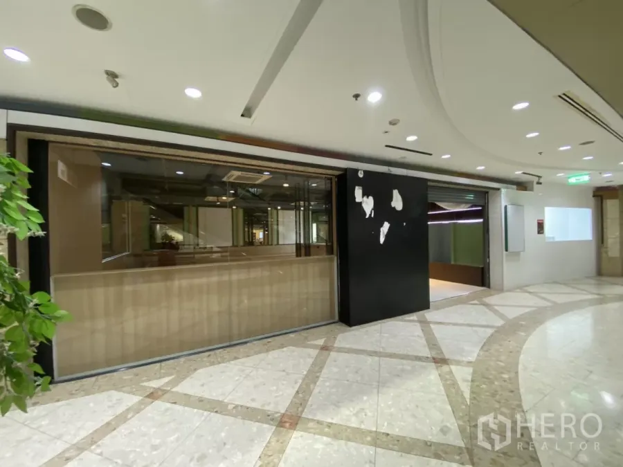 零售空间 出租 - 商场内玻璃门面店铺，黑色招牌与弧形大理石走道