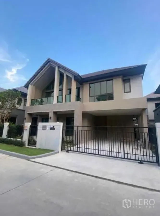 Detached House for rent in Lak Si, Bangkok - Modern two-storey detached house with tall gable roof, double-height windows and a gated driveway.