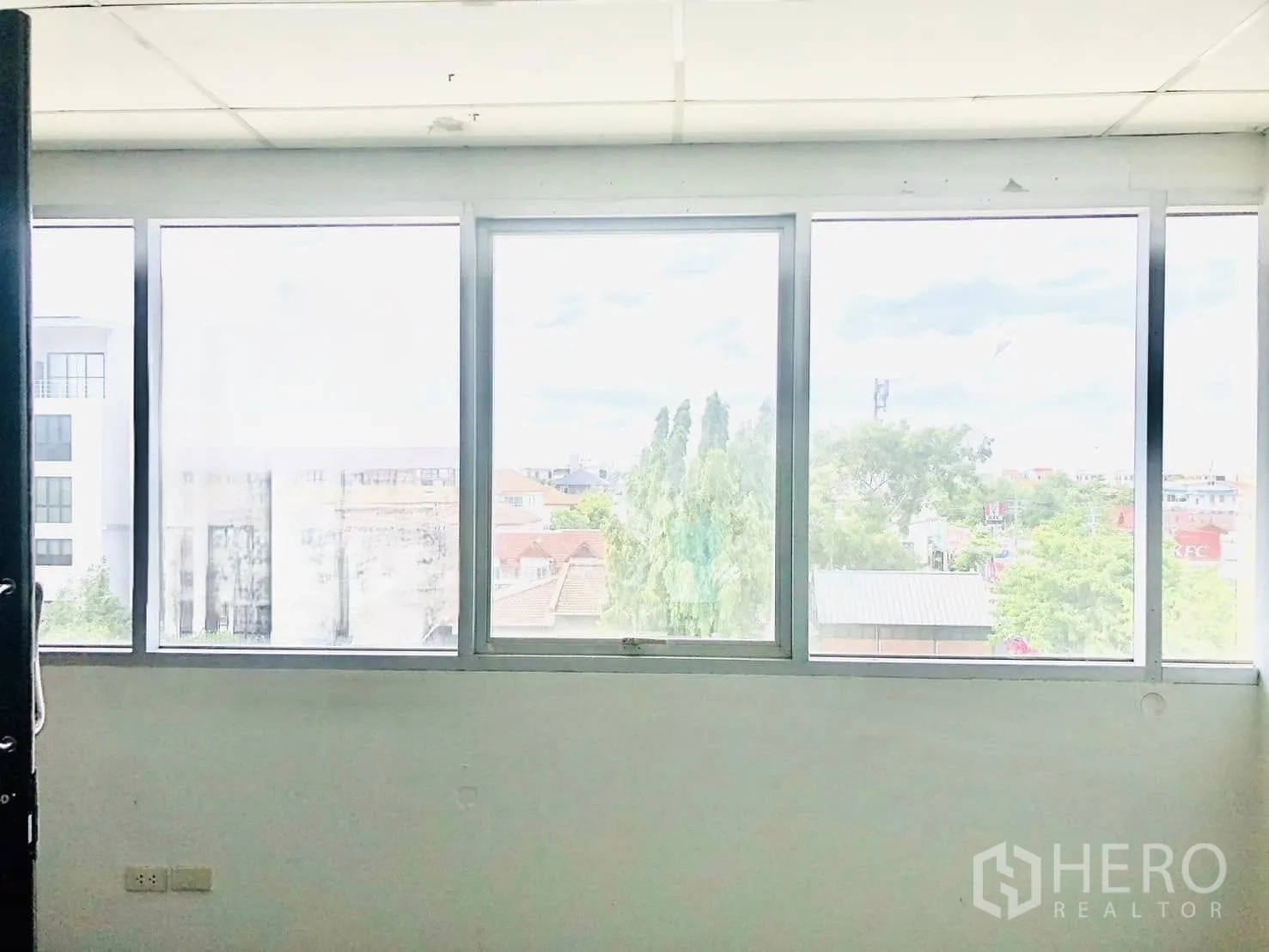 Office Space for rent in Lat Phrao, Bangkok - Interior wall with a row of large windows bringing natural light into the office.