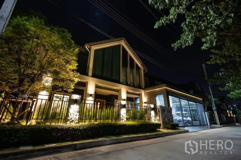 Detached House for sale in Pak Kret, Nonthaburi - Night exterior of the house with warm architectural lighting and glass‑walled garage.