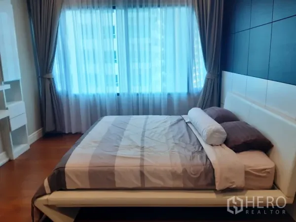 คอนโด ให้เช่าในKhlong Toei, Bangkok - ห้องนอนสว่าง พร้อมหน้าต่างบานใหญ่ ผ้าม่าน หัวเตียงบุหนัง และพื้นไม้ในคอนโดคลองเตย