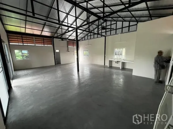 Warehouse for rent in Suan Luang, Bangkok - Open-plan warehouse interior with high steel truss roof and polished concrete floor.