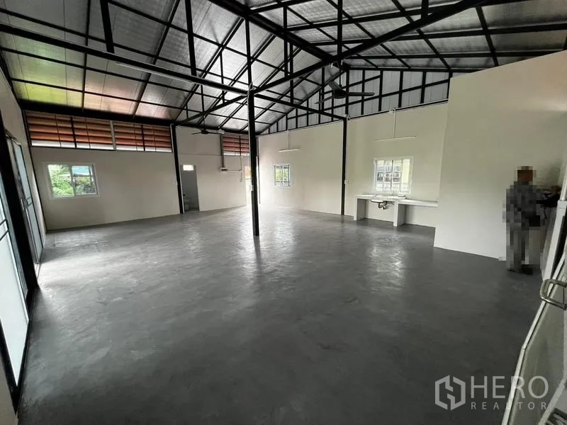 Warehouse for rent in Suan Luang, Bangkok - Open-plan warehouse interior with high steel truss roof and polished concrete floor.