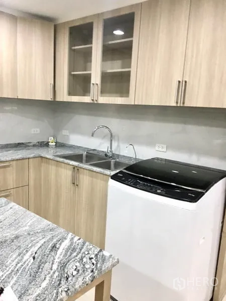 公寓 出租在Watthana, Bangkok - 厨房一角，双水槽、石材台面与顶开式洗衣机