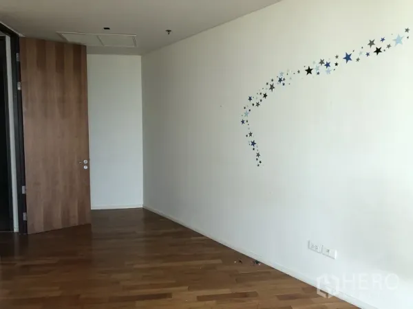 คอนโด ให้เช่าในKhlong Toei, Bangkok - ห้องอเนกประสงค์โล่ง พื้นไม้ ประตูไม้ สติกเกอร์ดาวบนผนังสีขาว