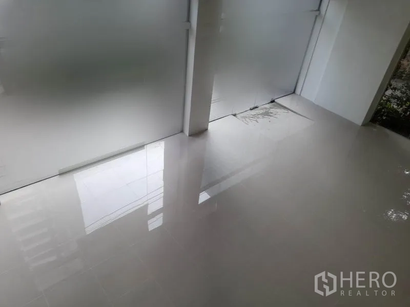 零售空间 出租在Ratchathewi, Bangkok - 靠近商铺玻璃门的瓷砖地面特写，适合张贴标识。