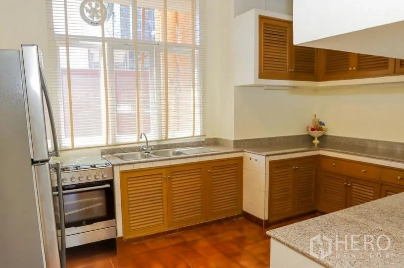 อพาร์ทเมนท์ ให้เช่าในPathum Wan, Bangkok - ครัวปิดเคาน์เตอร์รูปตัวแอลท็อปหินแกรนิต ตู้บานเกล็ด เตาอบ และหน้าต่างสูง