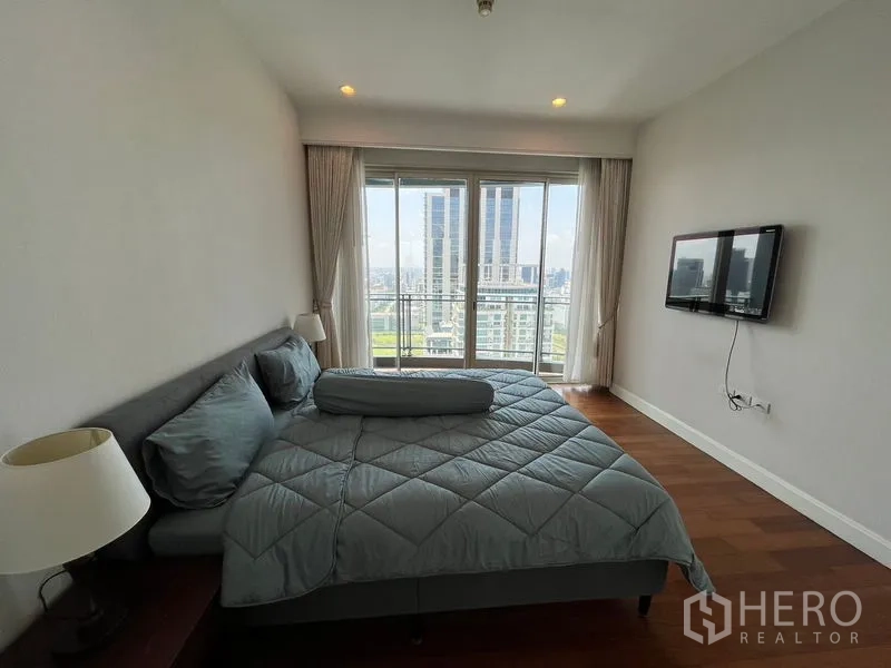 คอนโด ให้เช่าในPathum Wan, Bangkok - ห้องนอนเตียงคิงพร้อมประตูกระจกออกระเบียง เห็นตึกสูงในเมือง