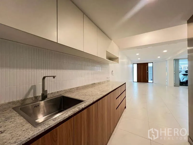 带办公室的家 出租在Khlong Toei, Bangkok - 一字型茶水间，花岗岩台面与水槽，上柜连接走廊。