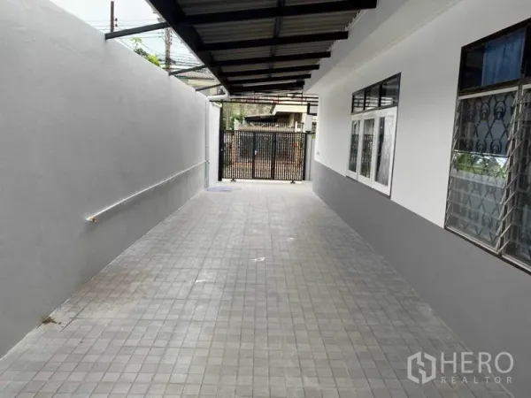 Detached House for rent in Huai Khwang, Bangkok - Covered tiled driveway and gated carport beside the house.