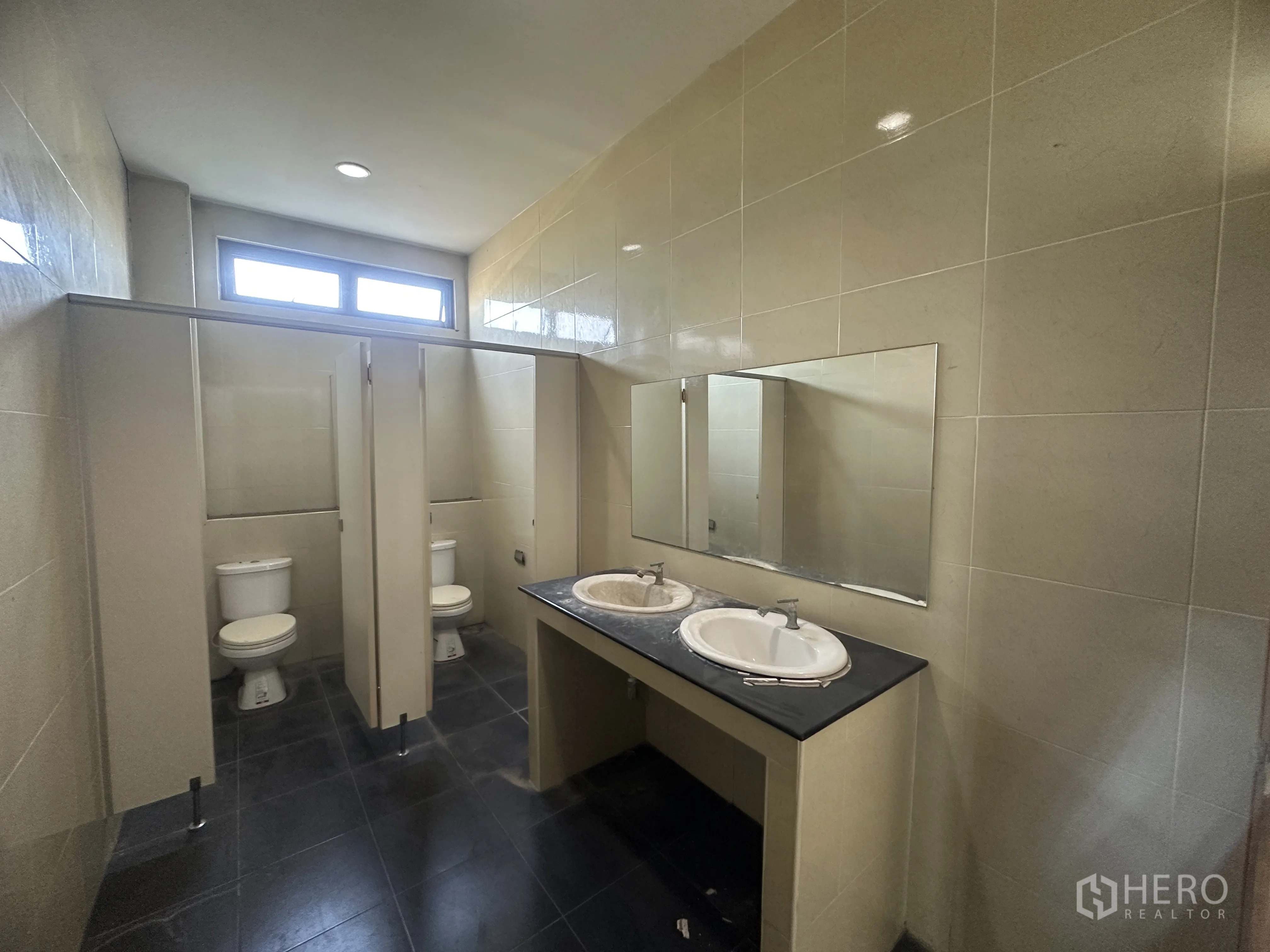 Factory for rent in Wang Noi, Phra Nakhon Si Ayutthaya - Restroom with cubicles, toilets, twin sinks, and a large mirror.
