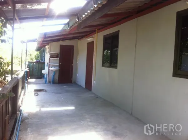 货栈 出租在Lam Luk Ka, Pathum Thani - 带顶侧走道，设有门窗、室外洗手池与栏杆，旁临绿化带。